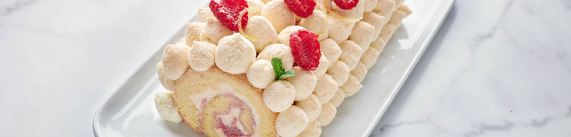 Raspberry and cream gateau roule on marble cake