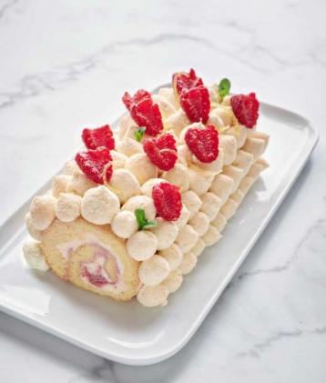 raspberry and cream gateau rolue on marble cake plate