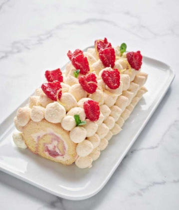 Raspberry and cream gateau rolue on marble cake plate