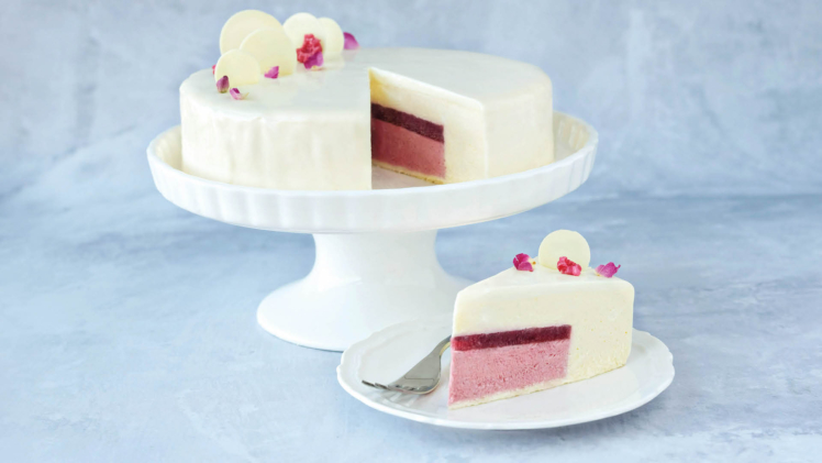 Raspberry and white chocolate entrement on cake stand and slice of cake on plate