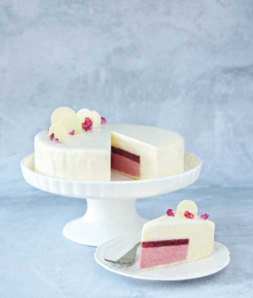 raspberry and white chocolate entrement on cake stand and slice of cake on plate