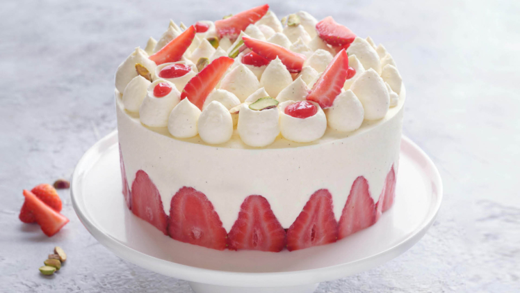fraisier cake on cake stand with strawberries surrounded