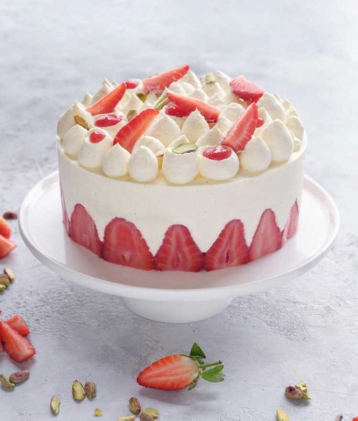 fraisier cake on cake stand with strawberries surrounded