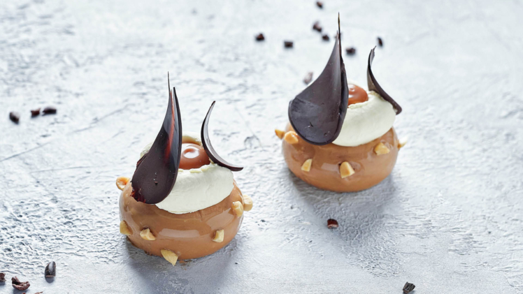 Two peanut banana and chocolate petit gateau on table